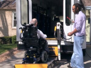TNC Community individual being helped into van by staff